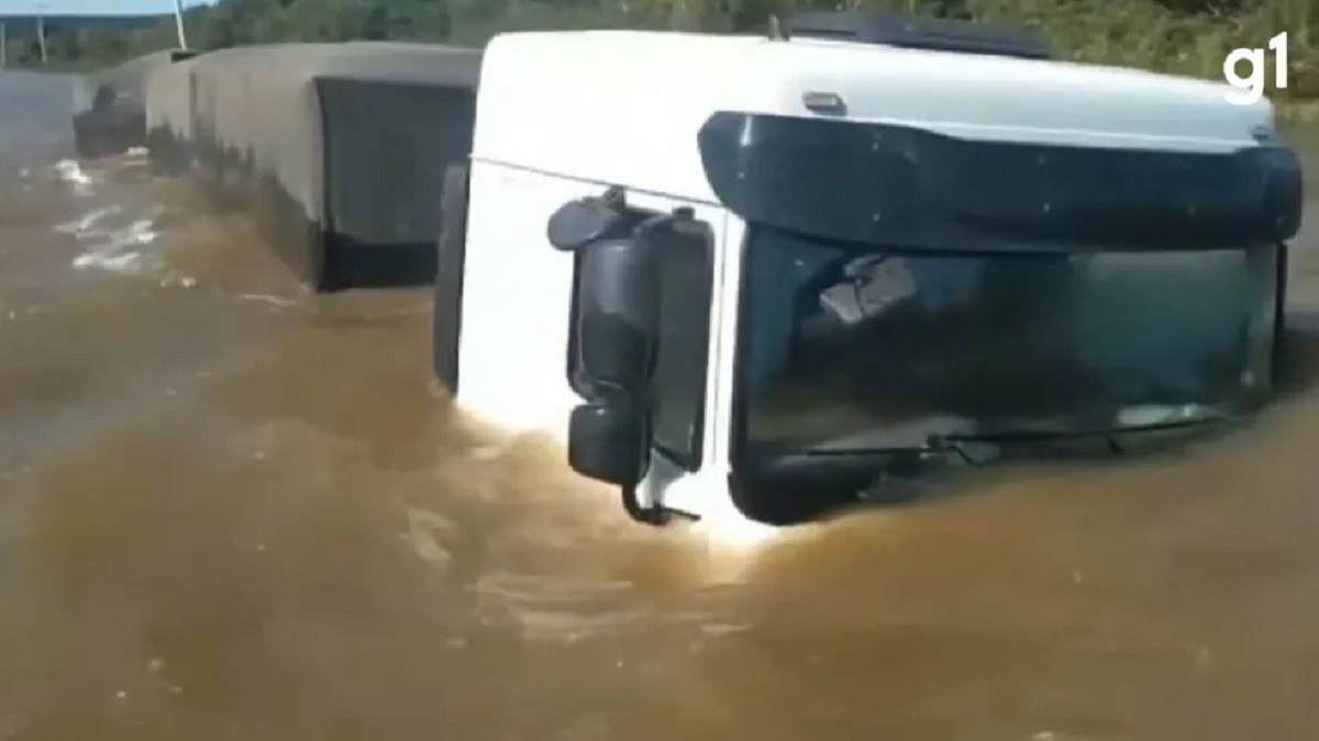 Motorista que conduzia o veículo teve que subir na cabine para não ficar submerso. Ele foi avistado por pescadores, que acionaram o Corpo de Bombeiros para fazer o resgate.