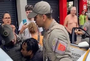 Homem negro vítima de facada é detido pela BM em Porto Alegre, enquanto o suposto agressor conversa com policiais | Foto: Renato Levin Borges